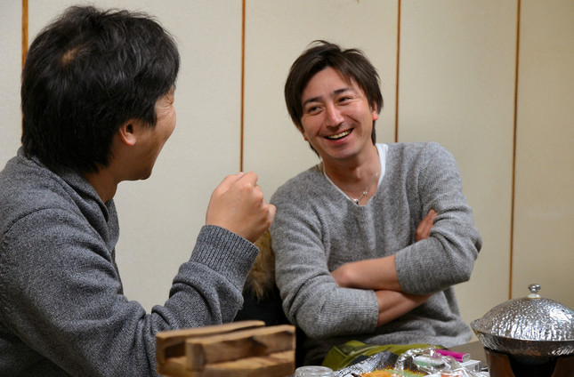 管野さんと食事を囲みながら話す菊地基文さん（写真右）