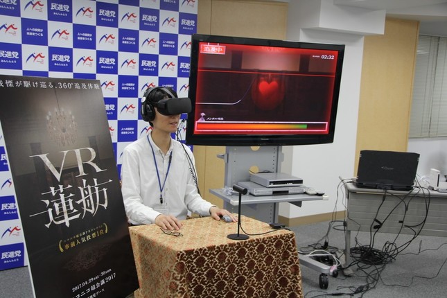 VR蓮舫を体験するJ-CASTニュース記者。中央のディスプレーに心拍数に応じて減少するゲージが表示されている