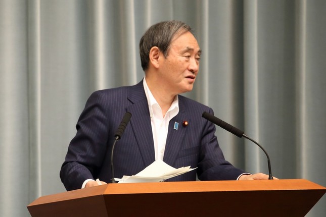 記者会見する菅義偉官房長官。困惑しながら秘書官に視線を送っていた
