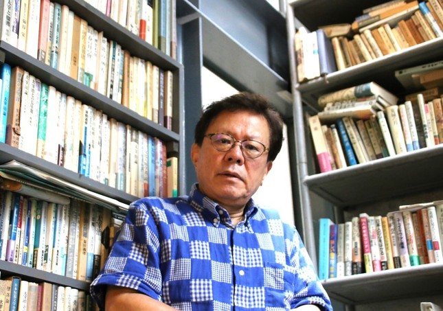 自身のオフィスの書棚の前に立つ猪瀬直樹氏。書棚の高さは10メートルにもなる