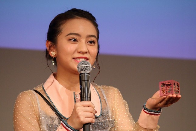 360度カメラつきのモジュール「ENJOY ONE」の模型を手にする岡田結実（ゆい）さん。2020年の打ち上げを目指す