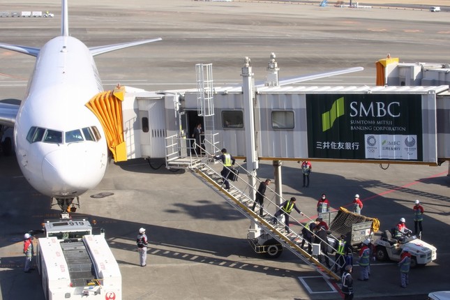 定刻から15分ほど過ぎた0時15分頃の様子。トランクケースをバケツリレーのようにして機内に運び込んでいる