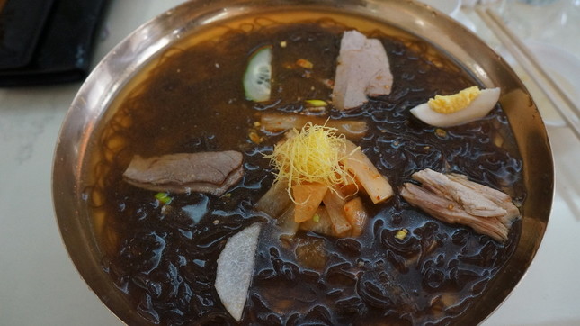 玉流館の平壌冷麺。黒っぽい麺が特徴だ（Uri Tours撮影、Wikimedia Commonsより）
