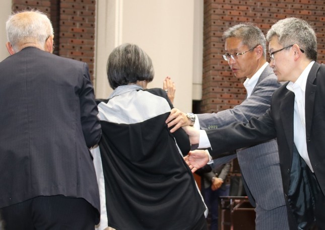 会見場から連れ出される女性の後ろ姿（2018年5月25日撮影）