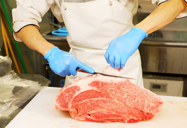 ブロック状の福島牛の肉を、手際よく処理する