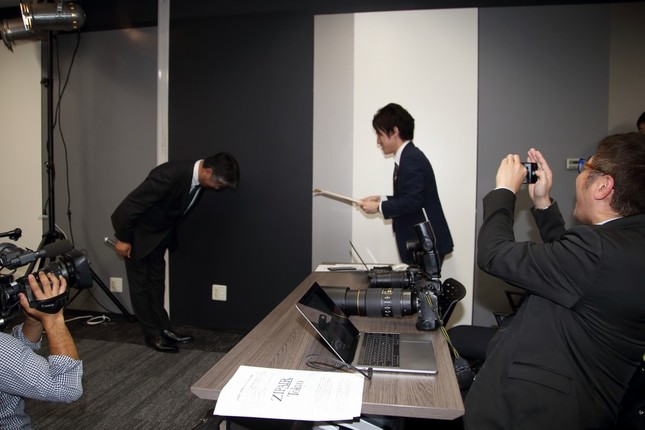 記者を「表彰」する西田真吾社長（左）