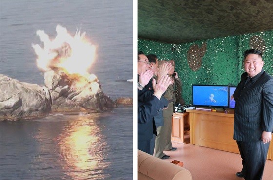 「飛翔体」が岩に命中し、その様子をモニターで見て喜ぶ朝鮮労働党の金正恩委員長（写真右、労働新聞から）