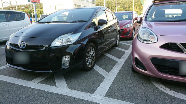 日置さんの車（右のピンク色のもの）の隣、斜線部分に別の乗用車が駐車している（写真提供：日置有紀さん）