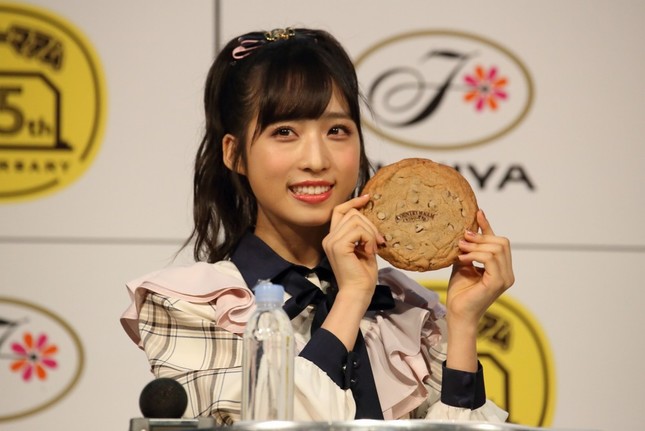 巨大なカントリーマアムを前に笑顔を見せるAKB48の小栗有以さん