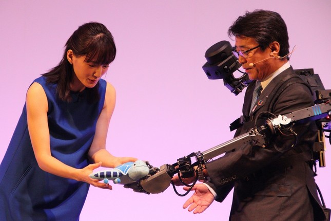 ぬいぐるみを「ウェアラブルアバター」と呼ばれるアバターロボットに手渡す綾瀬はるかさん（左）。右側はANAホールディングスの片野坂真哉社長