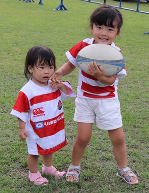 鹿児島から両親と一緒に来た妹の芽生ちゃん（左）と美生ちゃん。キッズ用のジャージを着た芽生ちゃんだったが、体が小さすぎて「ワンピース」になっていた（2019年9月28日撮影）
