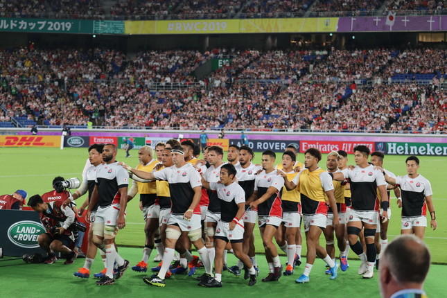 もはやお馴染みとなった光景。リーチ マイケル主将を先頭に肩に手を当てながら、試合前練習を終えてロッカールームに引き上げる代表選手たち