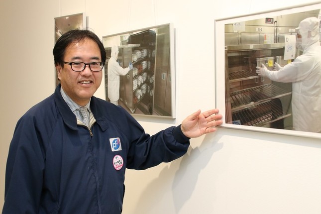 給食センター内の作業を写真で説明する渋谷昌俊社長