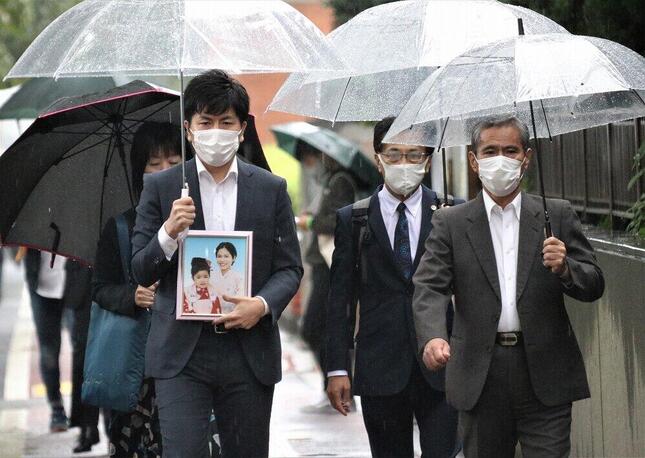 初公判前、真菜さんと莉子ちゃんの遺影を持つ遺族の松永拓也さん（手前左）