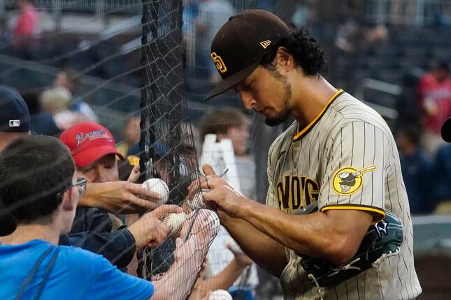 雨の中でサインを続けるダルビッシュ有投手（アトランタの試合で、写真：AP/アフロ）