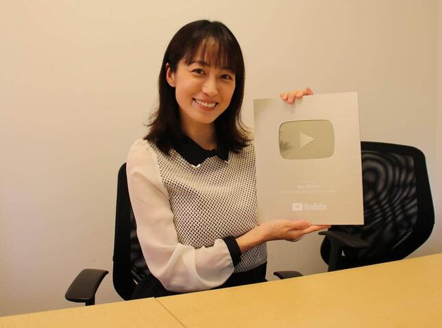 YouTubeの10万人達成記念「シルバークリエイターアワード」を手に微笑む及川さん
