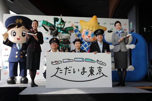 「ただいま東京」キャンペーンの記者発表会では、各社の制服姿の乗務員やマスコットキャラクターが一堂に会した。前列左からJAL、JR東海、東京メトロ、JR東日本、ANA。後列左から「駅街かける」（東京メトロ）、「シンカリオン」（JR東日本）、「ソラカラちゃん」（東京スカイツリー）、「ずらしmado（マドゥ）」（JR東海）