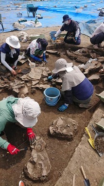遺物を掘り出す発掘調査のメンバーら（写真は、南アルプス市教委提供）