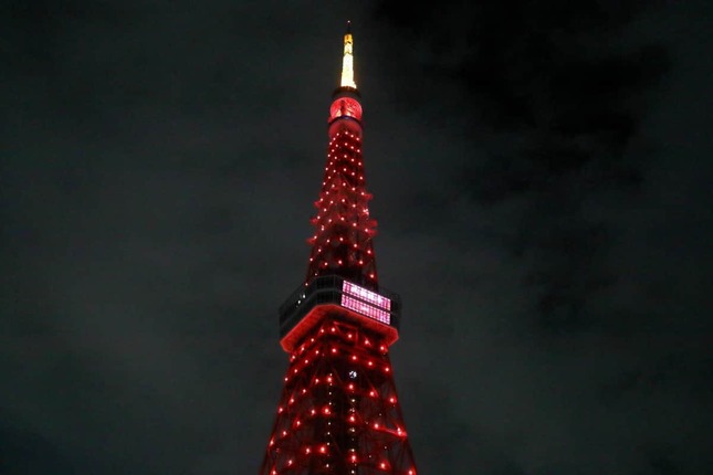 赤くライトアップされた東京タワー。展望台メインデッキの窓にはLEDで「祝福龍年」の4文字が投影された