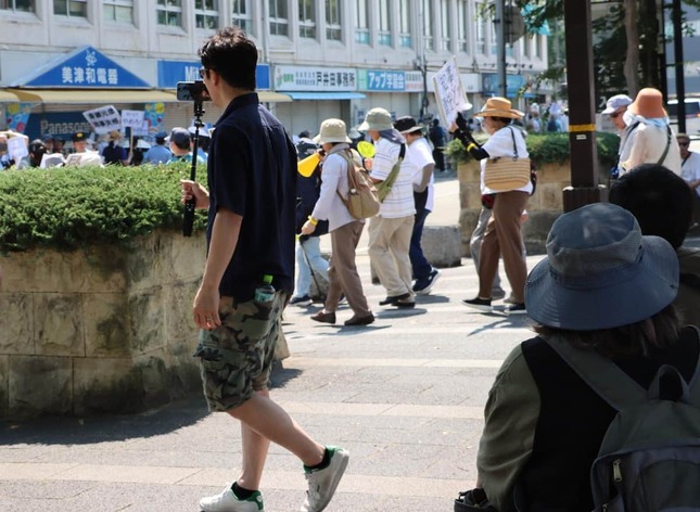 デモ隊について行きながら生配信する増山誠県議の姿も