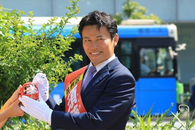 須藤氏はだるまの片目に墨を入れた