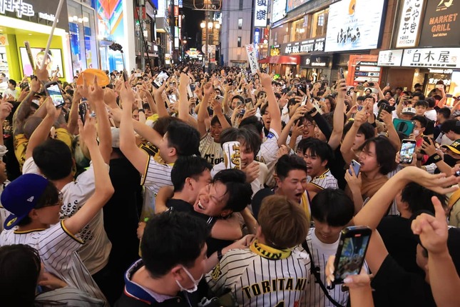 阪神の優勝を喜んで抱き合うファン（7日、大阪市中央区）