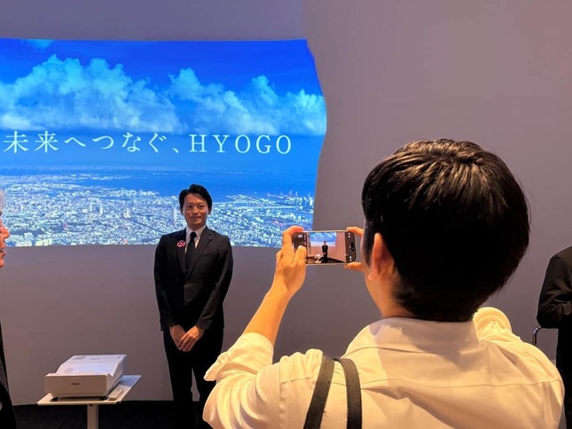 SNS投稿用とみられる写真を撮影する斎藤元彦知事（10月11日、大阪市此花区）