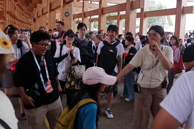 列を誘導するインドネシア館のスタッフ（写真両端）。「ヨヤクナシ」ソングが人気になった（2025年9月撮影）
