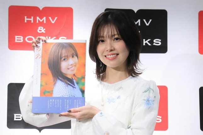 「HKT48 地頭江音々卒業写真集 ねね」（玄光社）を手に笑顔を見せるHKT48の地頭江音々さん