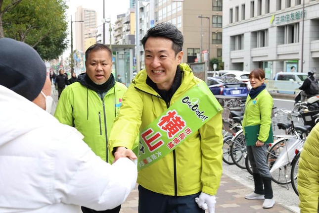 通行人と握手する横山英幸・前大阪市長（1月26日、大阪市北区）