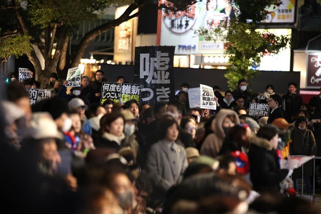 演説に対して抗議のプラカードを掲げる人々（2月7日、大阪・なんば）