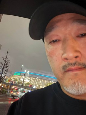 くまだまさしさん。東京ドーム近くで妻の「推し活」を応援している（くまださんのXから）