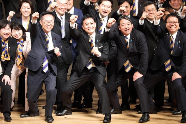 国民民主党の党大会終盤、壇上でこぶしを振り上げて笑顔を見せる党幹部。中央が玉木雄一郎代表