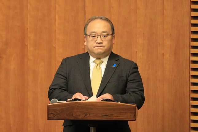 首相会見で司会を務める内閣広報官の佐伯耕三氏。アカウントの「中の人」だとみられる
