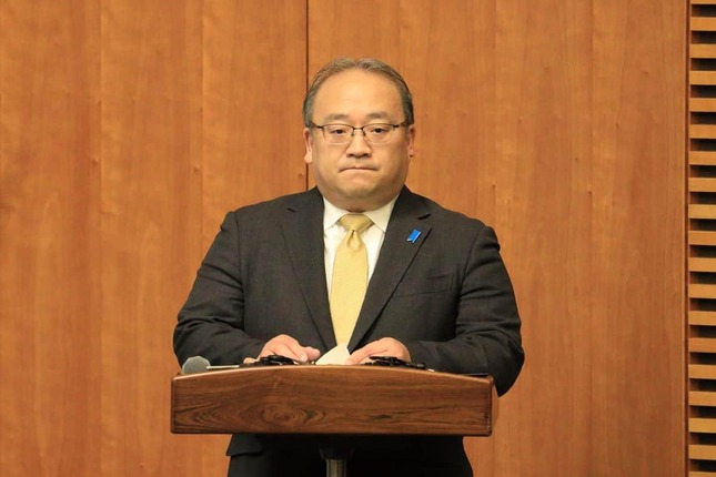 首相会見で司会を務める内閣広報官の佐伯耕三氏。アカウントの「中の人」だとみられる
