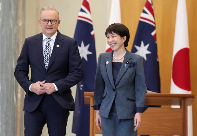 アルバニージー首相（左）の前で笑顔の高市早苗首相（右）。「内閣広報室試行アカウント」は現地紙「記事の全文仮訳」つきで「豪州訪問の成果」を強調している（写真：ロイター/アフロ）