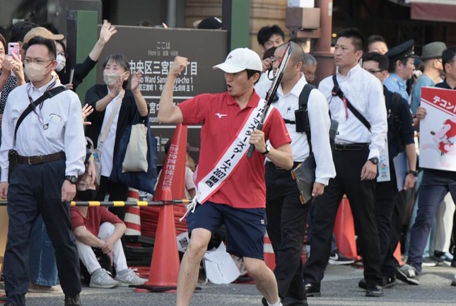 神戸まつりで、腕を見せてポージングする斎藤元彦知事（5月17日、神戸市中央区）