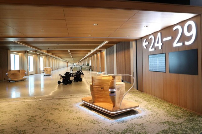 連絡通路の様子。4人乗りの自動走行モビリティ「iino」（右）や自動運転車いす「WHILL」（左）も無料で利用できる