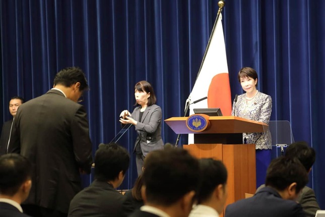 記者の質問を聞く高市首相。会見には手話通訳も入った