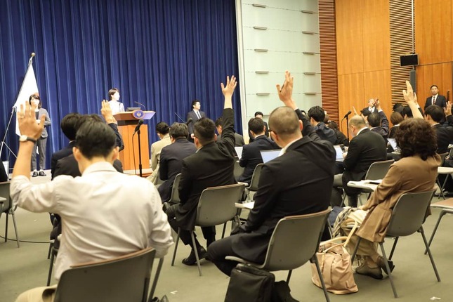 質問しようと一斉に手を挙げる記者たち。画面右で挙手するジャーナリストの江川紹子さんも指名されなかった
