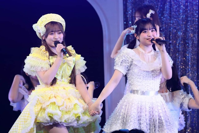 「君とどこかへ行きたい」でダブルセンターを務めた石橋颯さん（左）と7期生の龍頭綺音さん。石橋さんにとって初選抜曲となった楽曲を、後輩と手をつないで披露した