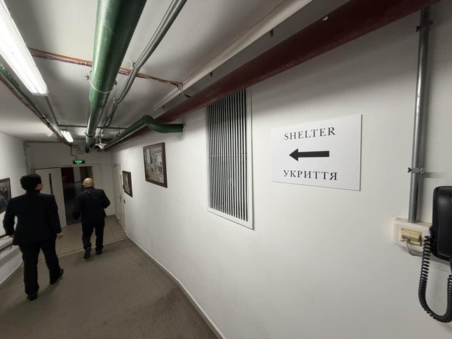 キーウの建物内に設けられたシェルターへの通路。壁には英語とウクライナ語で避難場所を示す案内板が掲げられている（写真提供：深作ヘスス事務所）
