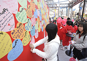 壁一面埋め尽くされた「Happy Message」。伝えたい想いを書き込んだあとは、嬉しそうな笑顔をのぞかせていた