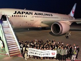 成田空港に到着したJALのボーイング787型機。社員が横断幕で迎えた