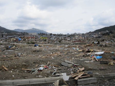 震災直後の小河原地区（手前が海）　画面奥の見える細長く白い建物は中学校