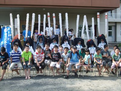 子供鹿踊りのみんなと記念撮影。福島の子どもたちはメッセージを書いた手製のうちわをお礼にプレゼント＝花巻市東和町のとうわボランティアの家で