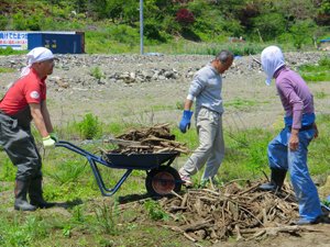 AAR職員も瓦礫や岩の撤去作業を一部お手伝いしました。大きな岩が多く、予想以上に重労働でした。中央は「ふれあい農園」発起人の高橋義弘さん、左は仙台事務所の大原真一郎（宮城県女川町、2012年5月24日）