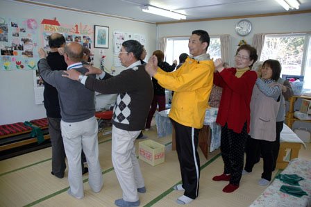 体操の最後に互いに肩をたたき合う住民たち＝2013年4月12日、大鎚町柾内の「大槌仮設団地」