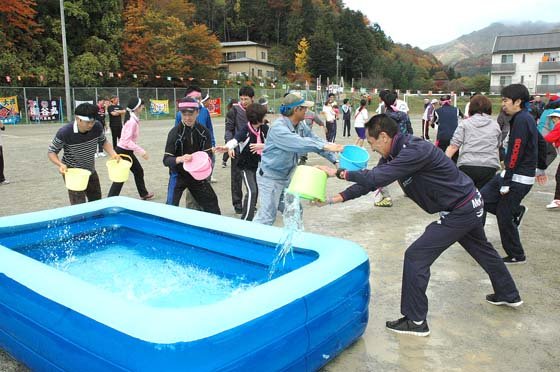 運んだバケツの数で順位をつけた「バケツリレー」＝2014年11月2日、大槌町の大槌小・中学校仮設グラウンド