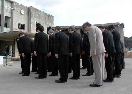 旧役場庁舎前で黙とうする町の幹部職員＝2014年3月11日、大槌町役場多目的会議室